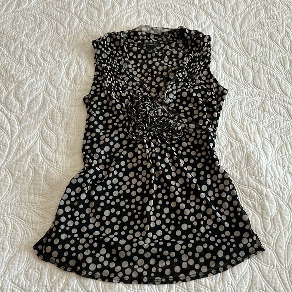 Sleeveless top with V neck. Darling rosettes at neckline.